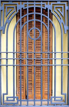 an ornate wooden door with metal bars on it