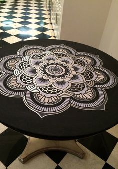 a black and white checkered floor with an intricate design on the table in front of it