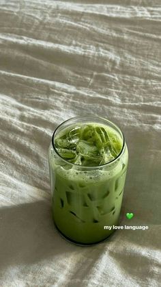 a green drink in a glass on a white tablecloth with the words my love language written below it