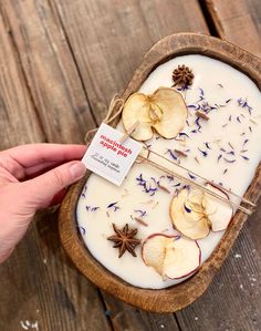 a wooden bowl filled with white liquid and dried flowers