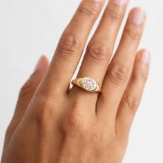 a woman's hand with a diamond ring on top of her left hand,