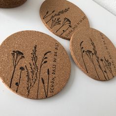 three cork coasters with plants engraved on them