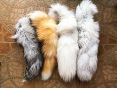 three different colored furs laying on top of a tile floor next to each other