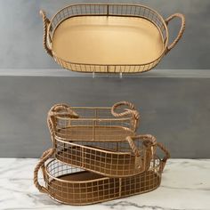 three metal trays sitting on top of a marble countertop next to each other