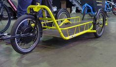 two people are standing next to some bikes with yellow bars on the front and rear wheels