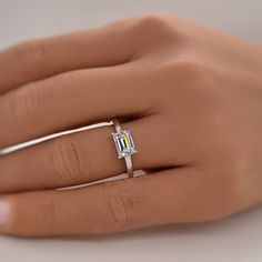 a woman's hand with a diamond ring on it