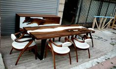 a wooden table with white chairs and a horse head on the wall behind it in front of a garage door