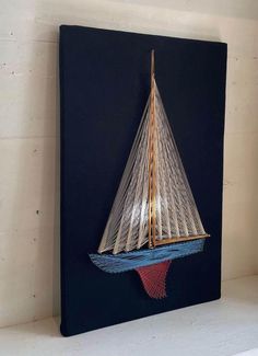 a sailboat made out of wire on a shelf