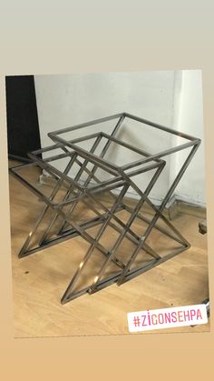 three pieces of metal sitting on top of a wooden floor