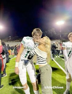 two football players are kissing on the field