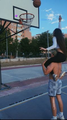 a man and woman playing basketball on an outdoor court