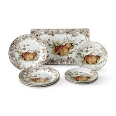 a set of four dinner plates with pumpkins on the front and bottom, along with two