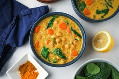 three bowls filled with different types of food next to oranges and spinach leaves