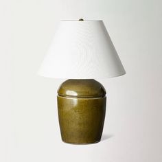 a lamp that is on top of a table next to a white wall and floor