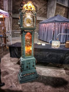 an antique clock on display in front of a tent