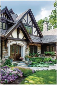 a house with lots of flowers and plants in front of it's entrance door