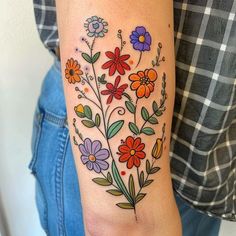 a colorful flower tattoo on the arm