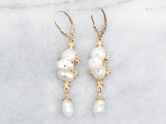 Add a touch of whimsy to your outfit with these drop earrings. Made with natural-shaped pearls on a yellow gold setting, these earrings are perfect for any occasion. Shine bright with these playful and elegant drop earrings! Metal: 14K Yellow Gold Gem: 8 Pearls Gem Measurements: 7.4 x 7.8 mm, Natural Shape Measurements: 11 x 55 mm SKU #: A39661 Each piece has been identified and graded by a Graduate Gemologist who has been certified by the Gemological Institute of America (GIA). We have six brick-and-mortar storefronts in Maine, Massachusetts, and New Hampshire and have been in business for over 25 years! Please visit our Shop's About Page or our website for more information about our jewelry. For questions about diamond grading, we recommend the  Gemological Institute of America (GIA), th Earrings Gold Pearl, Drop Earrings Pearl, Earrings Pearl Drop, Pearl Drop Earrings Gold, Drop Earrings Gold, Earrings Metal, Gold Pearl Earrings, Yellow Gold Setting, Earrings Pearl