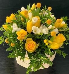 a bouquet of yellow and white flowers on a table