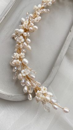 a gold and white bridal headpiece with pearls