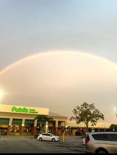 a double rainbow in the sky over a parking lot