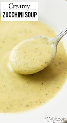 a spoonful of creamy zucchini soup in a white bowl with the title above it