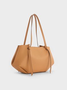 This Calla tote in beautiful toffee is a bag you will want to take with you to the office, pilates and everything in-between. The softly structured geometric silhouette with artfully sculpted folds makes it beautiful to behold from every angle. Along with its capacious interior, this bag will hold everything you need and more. It also comes with a detachable pouch to keep your belongings organised and easily accessible Office Pilates, Charles And Keith Bags, Charles And Keith, Bday Wishlist, Buy Bags, Luxury Purses, Bag Collection, Charles Keith, Fall Style