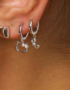 a close up of a person's ear with three different piercings on it