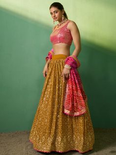 Introducing our lovely mustard sequins georgette haldi wears lehenga choli, a stunning ensemble perfect for special occasions. This beautiful lehenga choli set features a mustard yellow color georgette material lehenga adorned with exquisite sequin and embroidery work. Paired with a pink color georgette material choli featuring intricate sequin work, this set adds a touch of elegance and glamour to any event. To complete the look, a pink color organza dupatta with printed work and a beautiful se Reception Georgette Dupatta With Bandhani Print, Georgette Bandhani Print Dupatta For Reception, Reception Dupatta In Georgette With Bandhani Print, Yellow Bollywood Sharara With Sequins, Bollywood Style Yellow Sharara With Sequins, Orange Georgette Lehenga With Gota Work, Bollywood Yellow Sequin Set, Yellow Anarkali Choli With Sequins, Yellow Anarkali Set With Sequins