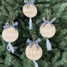 three wooden ornaments that say merry and peace hanging from a christmas tree with plaid ribbon