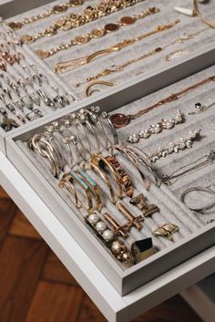 an assortment of jewelry is displayed on a white counter top in a display case that holds several necklaces and bracelets