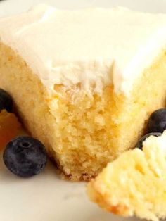 a piece of cake with white frosting and blueberries