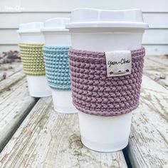 three coffee cups sitting on top of a wooden table