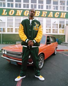 a man sitting on the hood of a car in front of a long beach store