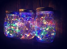 three mason jars filled with colorful string lights