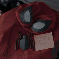 a spider - man costume with an i love you note attached to it