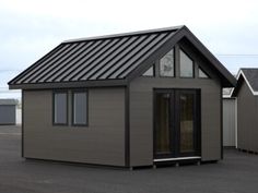 a small house with a metal roof and windows