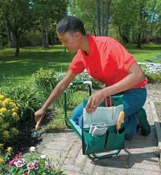 a woman kneeling down in the garden with gardening tools