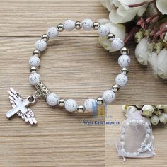 "These Wing of Angel bracelets are absolutely stunning Favors for baptism. 12 Pcs WHITE ANGEL CHARM BRACELET - A meaningful and useful favor for Baptism and religious events The Wings of angel adorn with a beautiful enamel cross Each bracelet comes with WHITE ORGANZA GIFT BAG. Stretchy bracelet fits youth and adult wrists. Wood bead size 8mm, Charm size: .75\" x 1\", fits youth & adult" White Adjustable Rosary Bracelet For Wedding, White Rosary Bracelet For First Communion, White Adjustable Bracelet For Confirmation, Adjustable White Bracelet For Confirmation, White Spiritual Jewelry For Confirmation, Spiritual White Jewelry For Confirmation, Personalized White Beaded Bracelets For First Communion, Personalized White Beaded Bracelets For Baptism, Adjustable White Rosary Bracelet For Confirmation