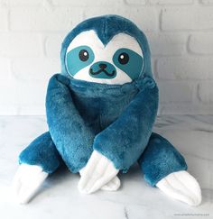 a blue stuffed slotty sitting on top of a white counter next to a brick wall