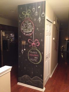 a chalkboard wall decorated with christmas ornaments and sayings on it's side