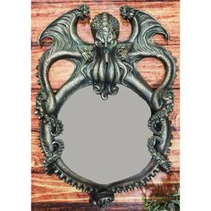 a mirror with an octopus design on the front and back of it, sitting on top of a wooden table