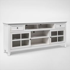 a white entertainment center with glass doors and drawers