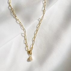 Genuine AA freshwater pearl paired with our best selling 14k gold filled paperclip chain; versatile. Slide the clasp up or down for a lariat or drop-style look. Length: adjustable up to 20” Chain: 14k gold filled medium paperclip chain Pearl: 8-9mm Lobster clasp Chain does not turn, tarnish, or rust Each natural pearl is unique and therefore no two are alike. Pearls, colors and sizes may vary. Handmade with the highest standards & quality materials Includes 100% organic cotton jewelry pouch This Gold Plated Chain Necklace With Pearl Charm For Everyday, Everyday Gold Plated Chain Necklace With Pearl Charm, Minimalist Gold Pearl Necklace With Paperclip Chain, 14k Gold-filled Pearl Charm Chain Necklace, Elena Necklace, Pearls Colors, Cotton Jewelry, Meaningful Jewelry, Cuff Rings