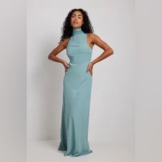 This Maxi Dress Features A High Neck With A Wide Self-Tie Knot At The Back Of The Neck, A Sleeveless Design, An Open Back, A Side Zipper Closure, A Flowy Fit And A Soft Material. This Maxi Dress Comes In Dark Blue. Materials: Shell: 55% Recycled Polyester, 45% Polyester. Lining: 100% Polyester. Blue Fitted Halter Neck Maxi Dress, Light Blue Fitted Maxi Dress For Date Night, Light Blue Sleeveless Dress With Tie Back, Sleeveless Light Blue Satin Maxi Dress, Light Blue Sleeveless Satin Maxi Dress, Fitted Maxi-length Halter Bridesmaid Dress, Fitted Maxi Length Halter Bridesmaid Dress, Fitted Maxi Length Halter Dress For Bridesmaids, Chic Fitted Halter Dress For Bridesmaid