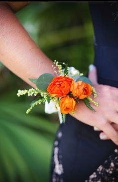 the bride's bouquet has orange flowers on it