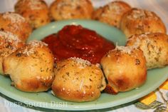 a green plate topped with pastries covered in sauce