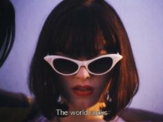 a woman wearing white sunglasses with the words, the world sucks