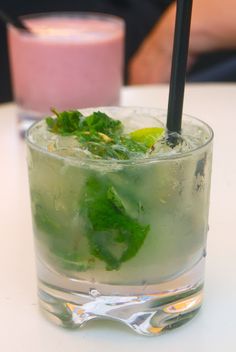 there is a drink with mint and lemon on the table