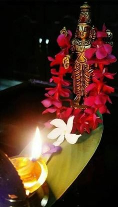 a lit candle and some flowers on a table